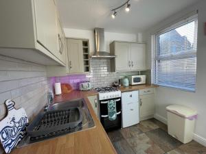 a kitchen with a sink and a stove top oven at Trout Cottage in Filey +30 photos