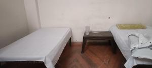 two beds in a small room with a table at Ladies homestay in Jhunjhunūn