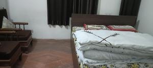 a bedroom with a bed with white sheets and red pillows at Ladies homestay in Jhunjhunūn