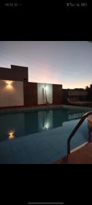a swimming pool with a light in the background at Suítes estrela dalva in Lauro de Freitas