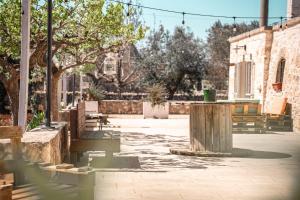 a park with benches and trees and a building at Trulli Beauty LAMIA family pool in Martina Franca