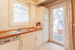 a kitchen with a sink and a door to a deck at Sekobbe 218 - Baabe in Baabe