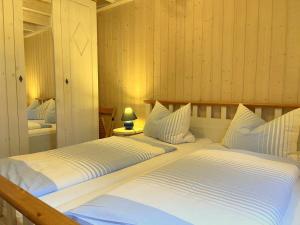 two beds in a room with wooden walls at Sekobbe 218 - Baabe in Baabe
