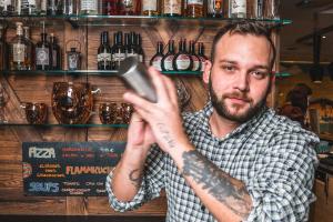 a man with a tattoo on his arm at a bar at Cocoon München Hauptbahnhof in Munich