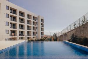 a swimming pool in front of a building at Atlantic Residence Pool & Ocean View in Câmara de Lobos