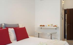 a bedroom with a bed with red and white pillows at San Siro - 1st Studio & free wifi in Milan