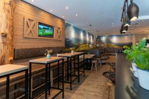 a restaurant with wooden walls and tables and plants at Cocoon München Hauptbahnhof in Munich