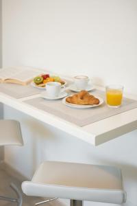 a breakfast table with croissants and a glass of orange juice at San Siro - 1st Studio & free wifi in Milan