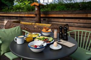 a black table with breakfast foods on it at Cocoon München Hauptbahnhof in Munich