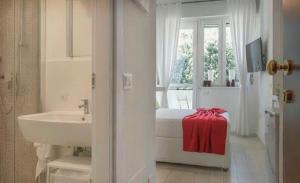 a white bathroom with a sink and a bed and a window at San Siro - 1st Studio & free wifi in Milan