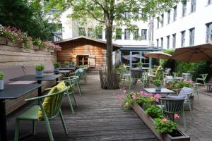 an outdoor patio with tables and chairs and flowers at Cocoon München Hauptbahnhof in Munich