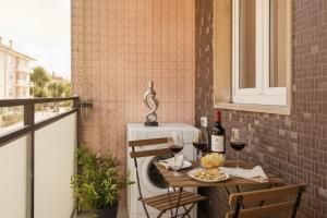 a table with two glasses of wine on a balcony at San Siro - 1st Studio & free wifi in Milan