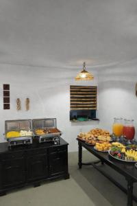 two buffet tables with plates of food on them at Pousada Pé no Mar in Japaratinga