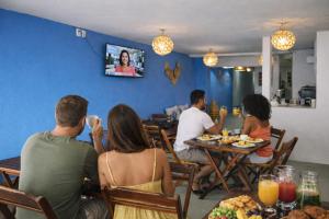 a group of people sitting at a table in a restaurant at Pousada Pé no Mar in Japaratinga
