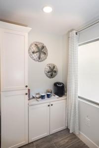 a kitchen with white cabinets and a window at Lighthouse Point 222 in Sanibel