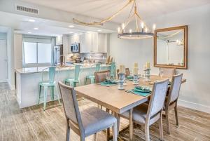 a dining room with a table and chairs and a kitchen at Lighthouse Point 222 in Sanibel