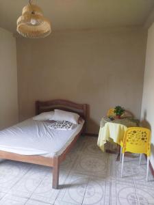 a bedroom with a bed and a table and a lamp at Suítes estrela dalva in Lauro de Freitas