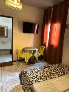a room with a table and chairs and a bathroom at Suítes estrela dalva in Lauro de Freitas