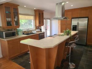 a kitchen with wooden cabinets and a large counter top at The Taunton House in Ajax