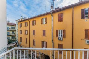 a yellow building with red windows and a balcony at Sempione Color Milano CityLife Fiera District in Milan
