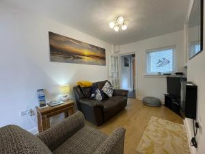 a living room with a couch and a tv at Trout Cottage in Filey