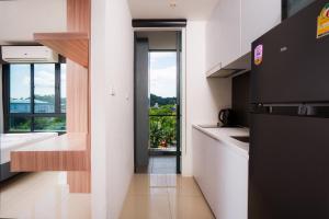 a kitchen with a refrigerator and a sink and a window at Propify Central Serviced Residence in Ban Ket Ho