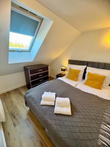 a bedroom with a large bed with two towels on it at Izerska Baza - basen, ebike, narty, sauna, jacuzzi, las blisko Świeradów Zdrój in Giebułtów +107 photos