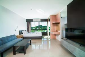 a living room with a couch and a tv at Propify Central Serviced Residence in Ban Ket Ho