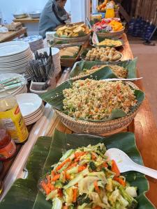 a table topped with plates of food on banana leaves at My village river side in Nongkhiaw