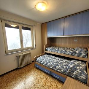 two bunk beds in a room with a window at Il Roseto Mountain Lake Iseo Hospitality in Bossico