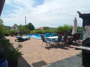 a patio with a table and chairs and a pool at Shining Home in Felsőörs +9 photos