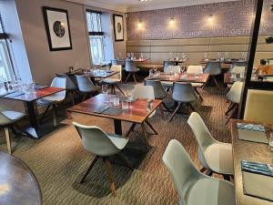 a restaurant with tables and chairs in a room at The Marine Hotel in Stonehaven