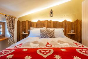 a bedroom with a large bed with a red blanket at Residence La Baita in Frassinetto