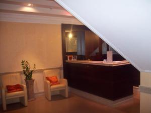 vestíbulo del hotel con 2 sillas y mostrador de recepción en Palmed Hotel, en Gizzeria