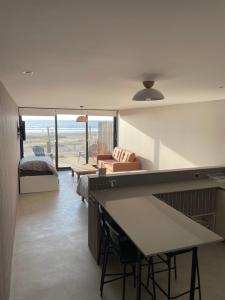 a living room with a bed and a table in a room at Rompe Olas in Maitencillo