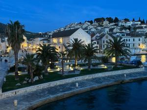a city with palm trees and buildings at night at Riva Lavanda Hvar, Old Town in Hvar