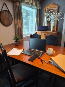 a laptop computer sitting on top of a wooden table at Huset Alcamaro - A Place to Work & Breathe in Haugland +39 photos