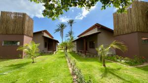 a row of houses with palm trees in the yard at Villa 4 Elements, Studios Praia de Saquaíra, Maraú in Marau