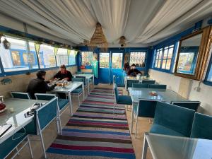 a restaurant with blue chairs and people sitting at tables at Dar kenza Tunis in Tunis