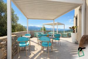 a patio with blue chairs and tables with a view at Hotiday Lerici Trebiano in Lerici