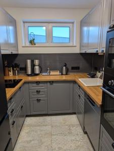 a kitchen with gray cabinets and a sink at Stadtnah an der Förde S1 in Flensburg +14 photos