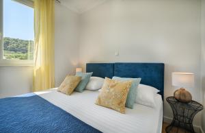 a bedroom with a bed with a blue headboard and pillows at Petra's Place - Sea view apartment in Slatine +22 photos