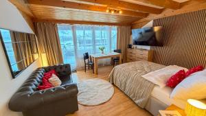 a bedroom with a bed and a desk and a television at PlanB Stay in Samedan
