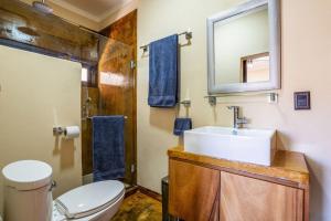 a bathroom with a sink and a toilet and a mirror at Pent house in Cabo Pulmo