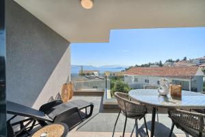 a patio with a table and chairs on a balcony at Petra's Place - Sea view apartment in Slatine
