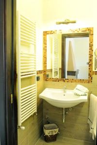 La salle de bains est pourvue d'un lavabo et d'un miroir. dans l'établissement Residence Les Amis, à Castel di Sangro