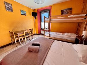 a bedroom with two bunk beds and a table and chairs at Hotel de la gare des Ecrins in LʼArgentière-la-Bessée