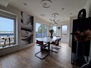 a dining room with a table and some windows at ATELIER DE BERCK - Gîte 6p avec Parking GRATUIT & TERRASSE in Berck-sur-Mer