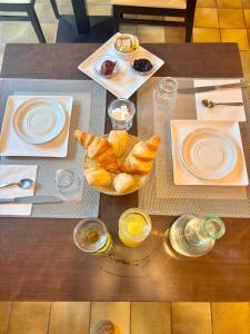 a table with croissants and plates of food on it at Hotel de la gare des Ecrins in LʼArgentière-la-Bessée +20 photos