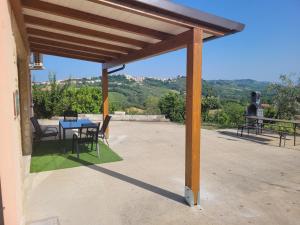 a wooden pergola with a table and chairs on a patio at Domus Quarticelli Costa dei Trabocchi in Torino di Sangro